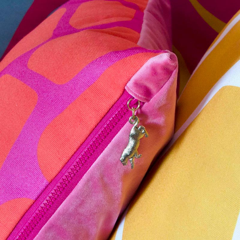 By John Designs red and pink African giraffe pattern scatter cushion with velvet and gold leopard pendent.